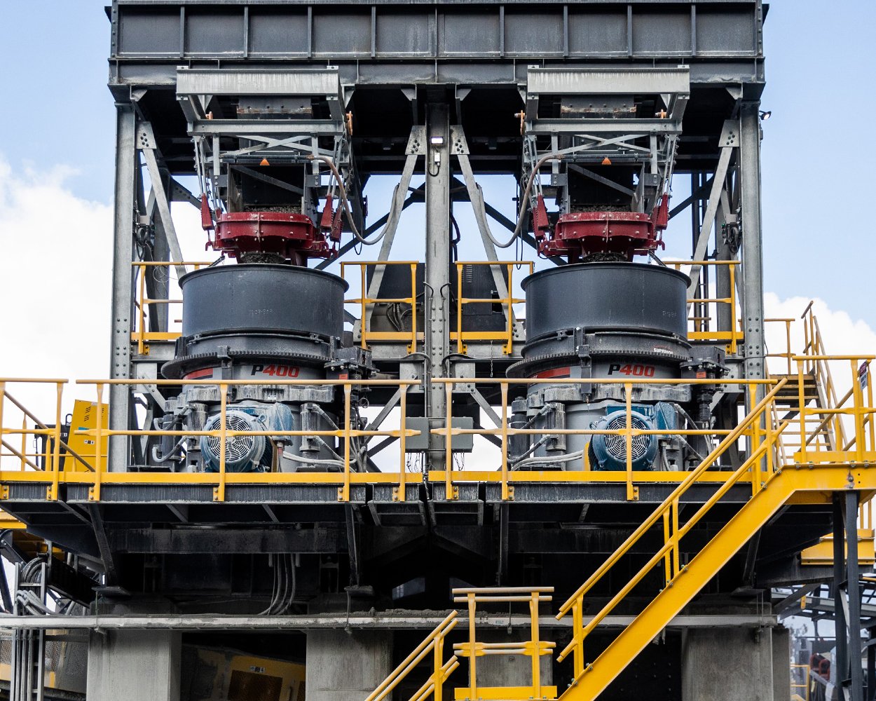 Pair of Patriot® Cone Crushers beneath surge bins in a stationary plant