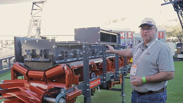 Joe Gibson touring a modular conveyor skirting system display at CONEXPO 2026
