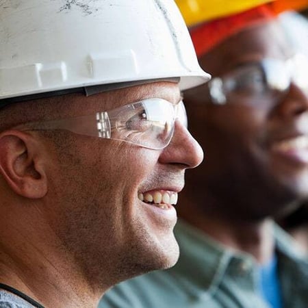 Two smiling construction professionals wearing hard hats and safety glasses, representing Superior’s lasting partnerships and commitment to supporting customers long after project completion