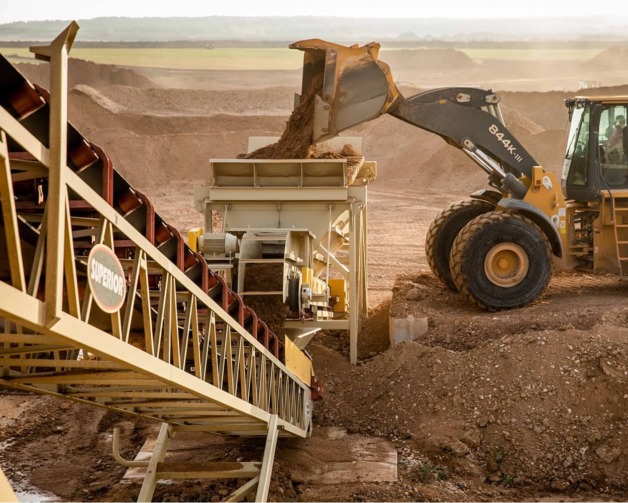 Wheel loader feeding material into a Fusion Plant at Alamo in Elgin, Texas