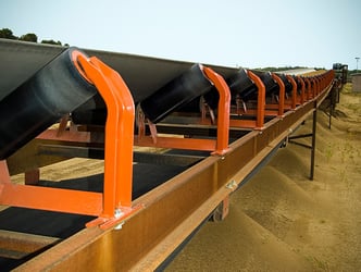 Idlers installed on a conveyor seen at belt level