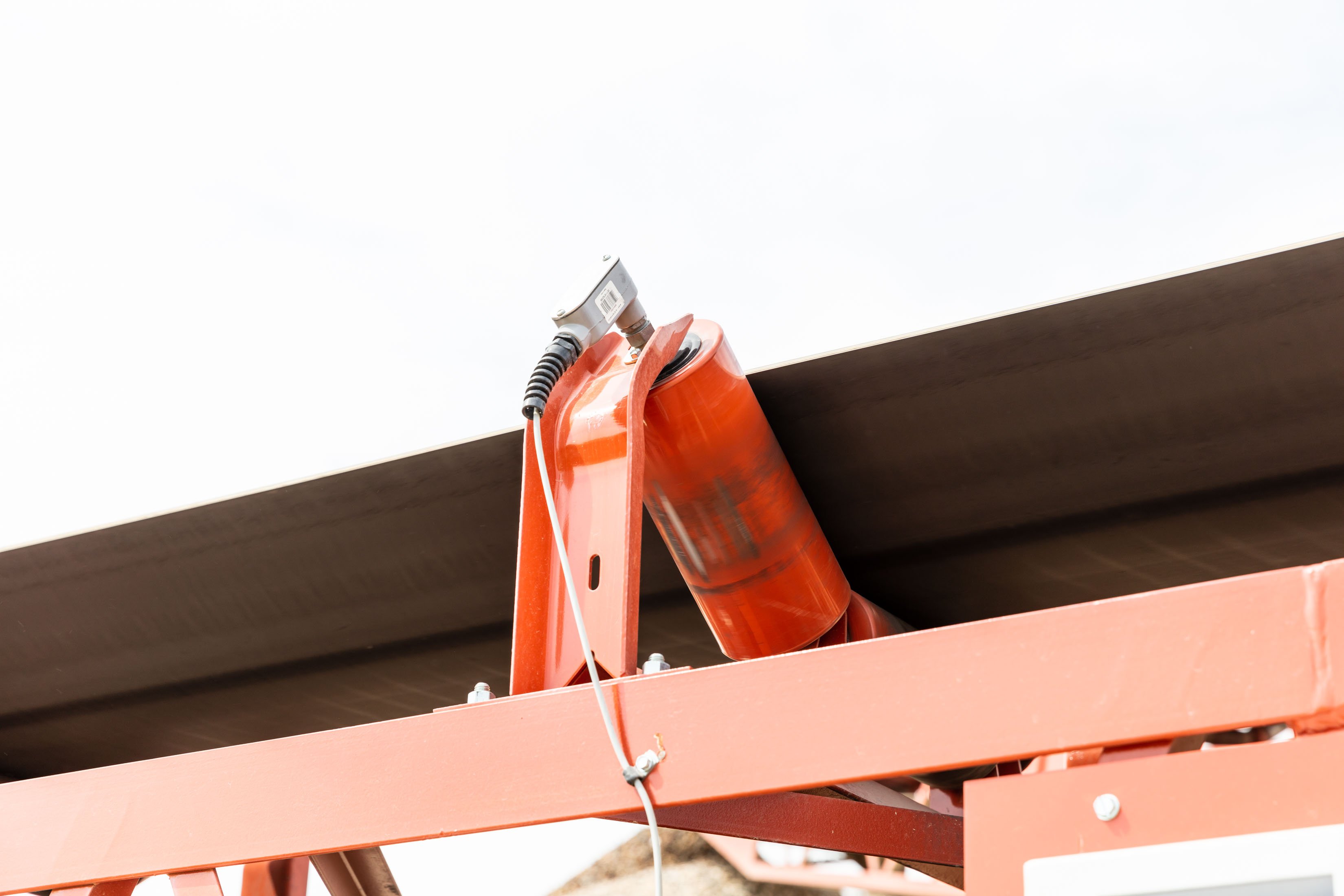 Belt speed sensor mounted onto conveyor next to the belt.