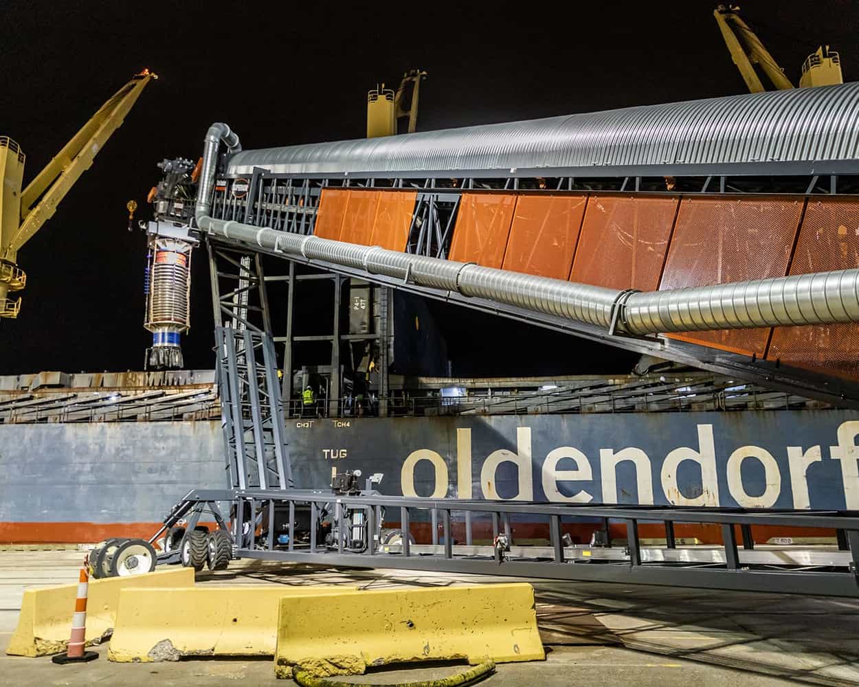 TeleStacker® Conveyor loading ship with wood pellets during nighttime port operation