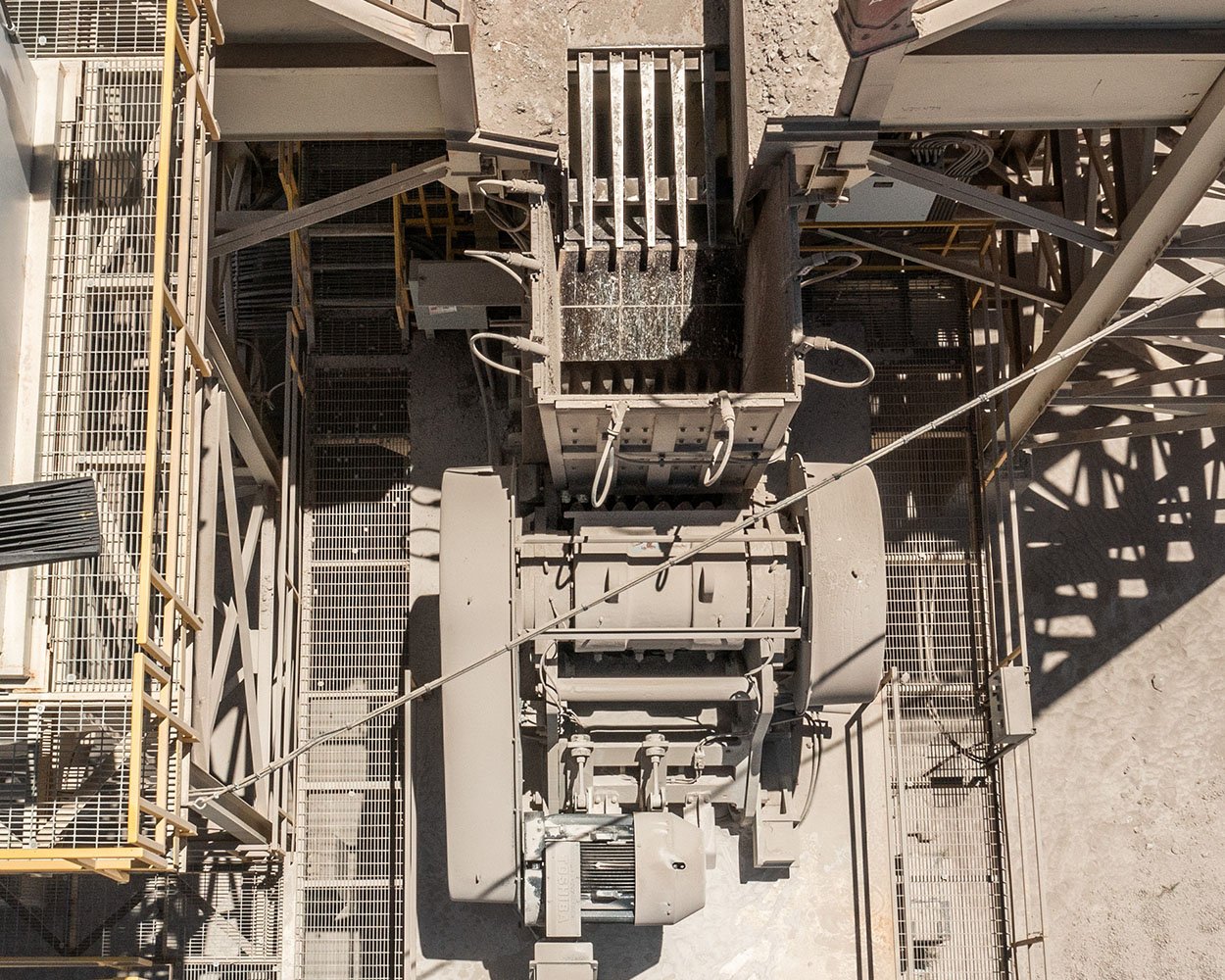 Intrepid® Vibrating Grizzly Feeder installed on stationary platform showing coil springs, bracing, and guarding