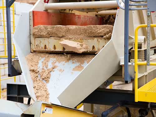 Dewatering Screen 5x10 model in top view discharging sand onto conveyor during operation