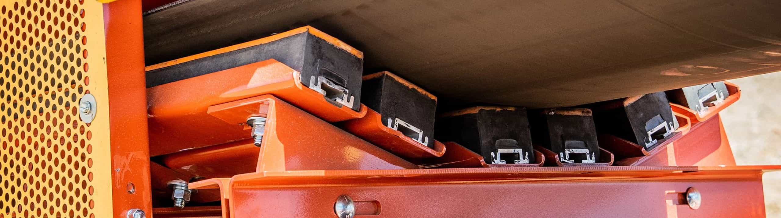 Closeup of load zone on aggregate conveyor displaying impact bed in position under the belt