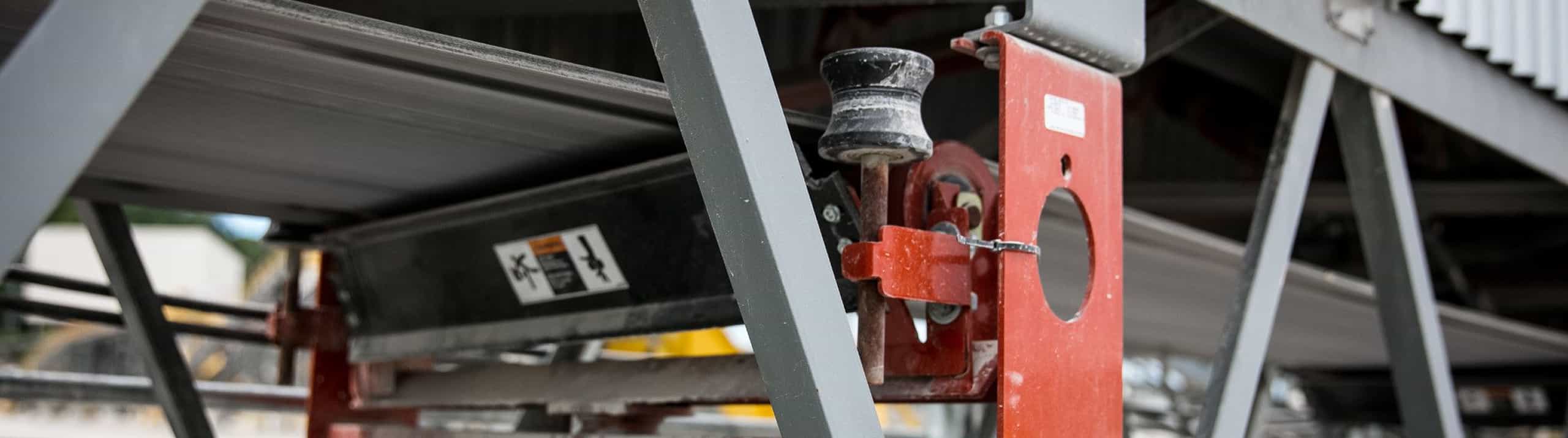 Self-aligning training idler in operatioin beneath conveyor belt