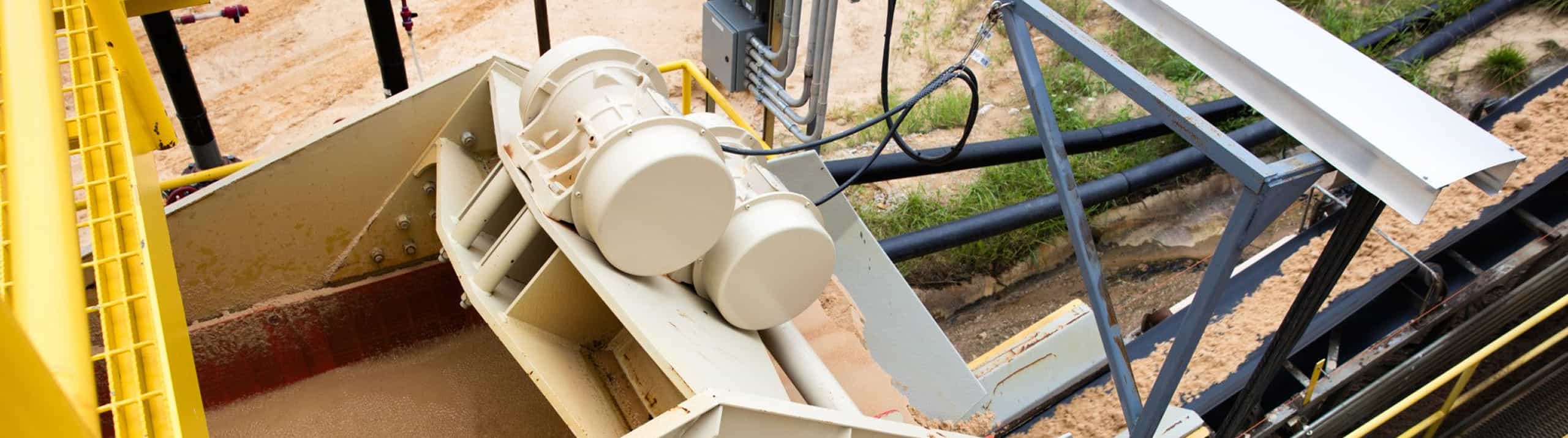 Top view of 5x10 Dewatering Screen in operation with dewatered sand falling into conveyor
