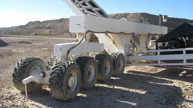 Superior® TeleStacker® Conveyor at a mining site, showing the conveyor structure mounted on a mobile wheeled base for automated material stockpiling.