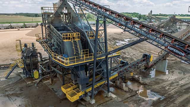 Superior® Stationary Transfer Conveyors moving material between processing units at an aggregate site, with multiple conveyors and support structures in operation.