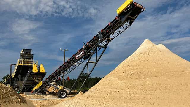 Superior® Radial Stacking Conveyor depositing processed material into a conical stockpile at an aggregate site.