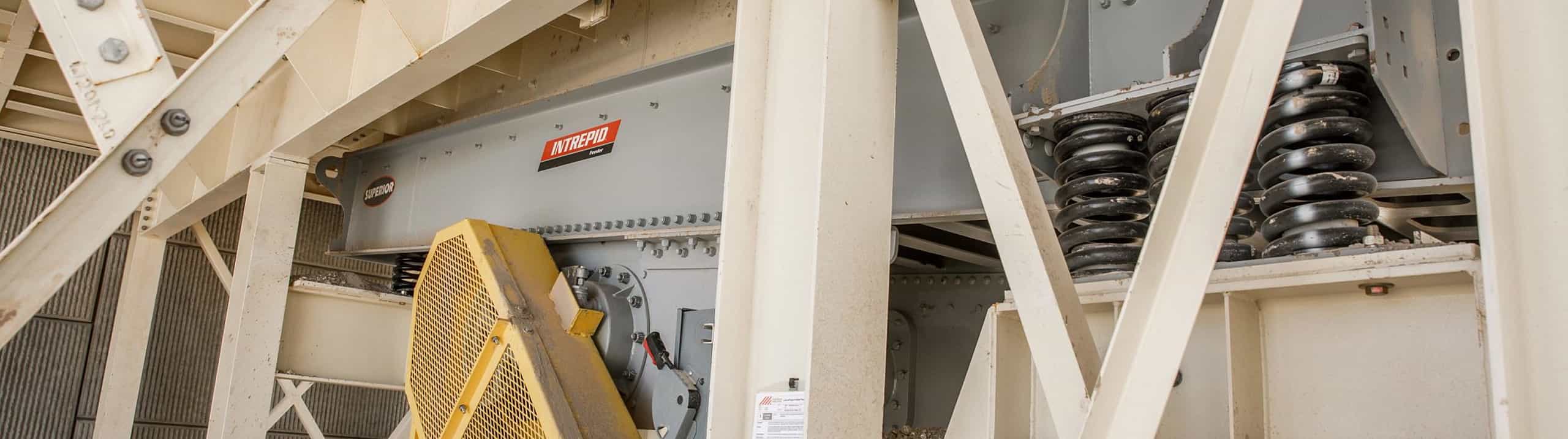 Intrepid® Vibrating Grizzly Feeder installed on a stationary platform with visible bracing, coil springs, and guards.