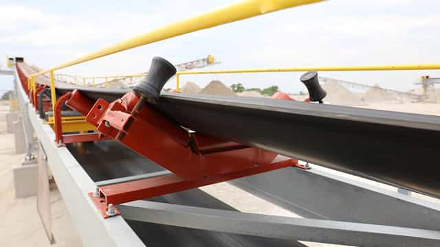 Superior® Training Idler on a conveyor system ensuring proper belt alignment at an aggregate processing site.