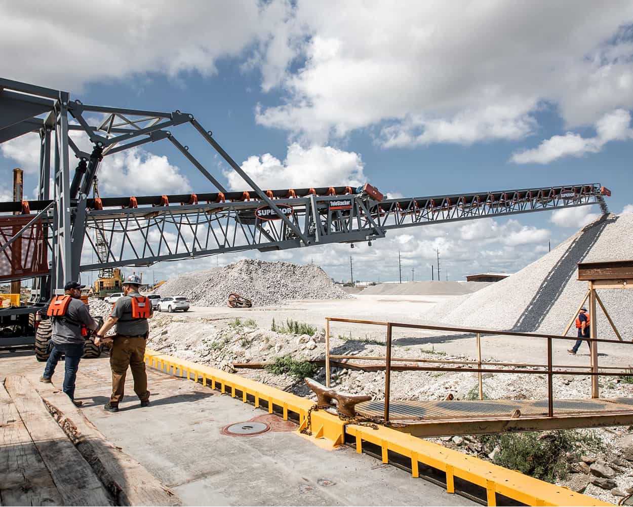 Superior barge-mounted Telestacker Conveyor offloading aggregate material at an inland terminal near New Orleans