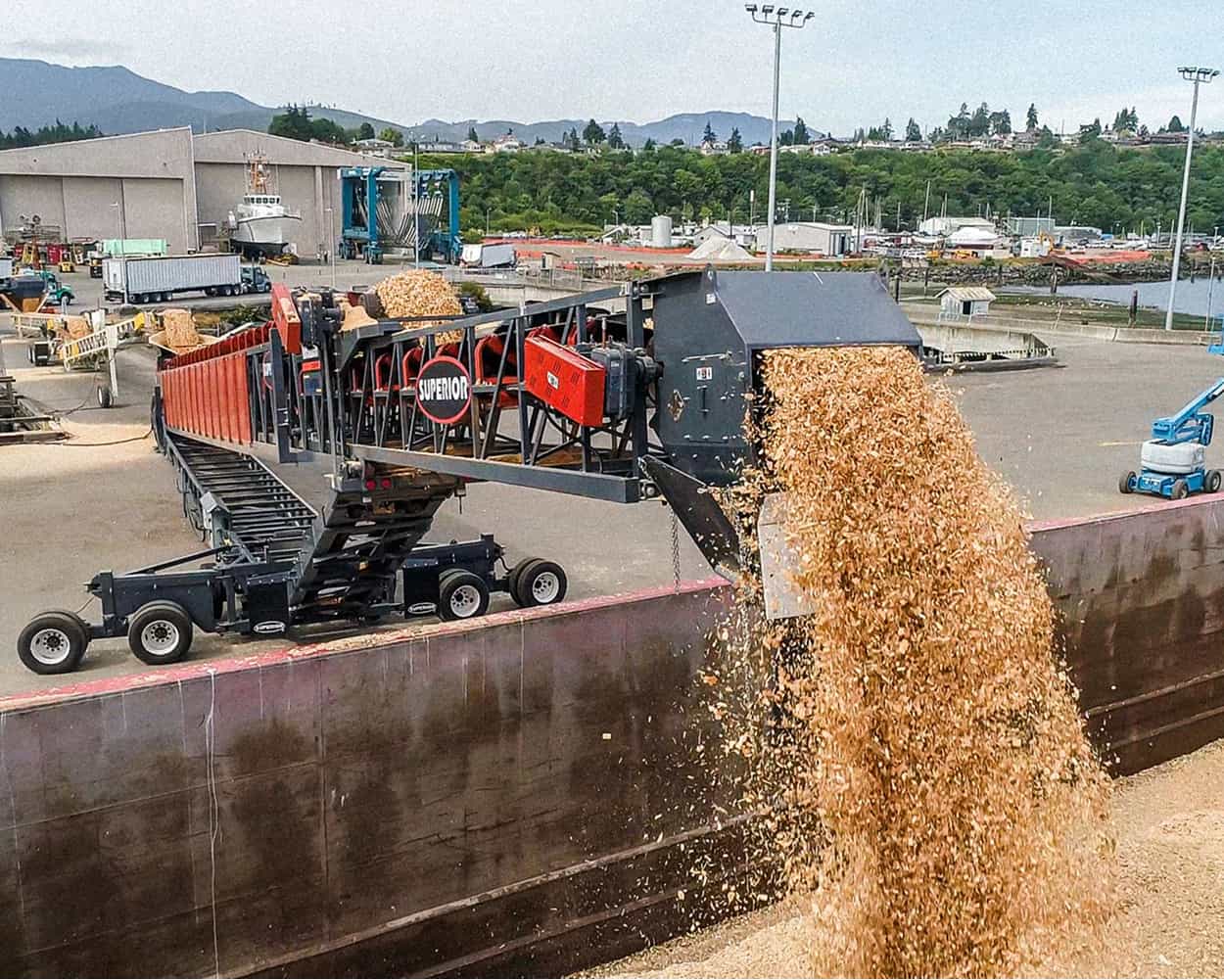 Superior TeleStacker® Conveyor loading wood chips into a barge at an organics handling facility