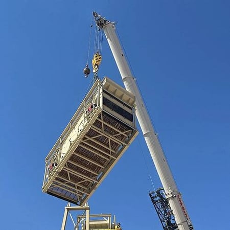 A crane lifts a horizontal screen into place as licensed Superior builders guide the installation
