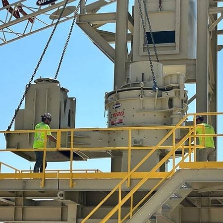 Two crew members in high-visibility safety gear guide equipment into place on a processing structure, reflecting Superior’s proven safety culture and record of zero onsite recordables