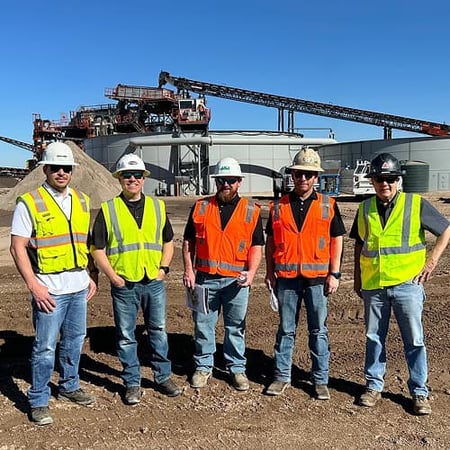 A group of representatives from Superior, a dealer, and an aggregate producer stand together
