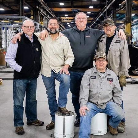 Five Superior employees pose together inside a warehouse facility, showcasing camaraderie, experience, and pride in their work