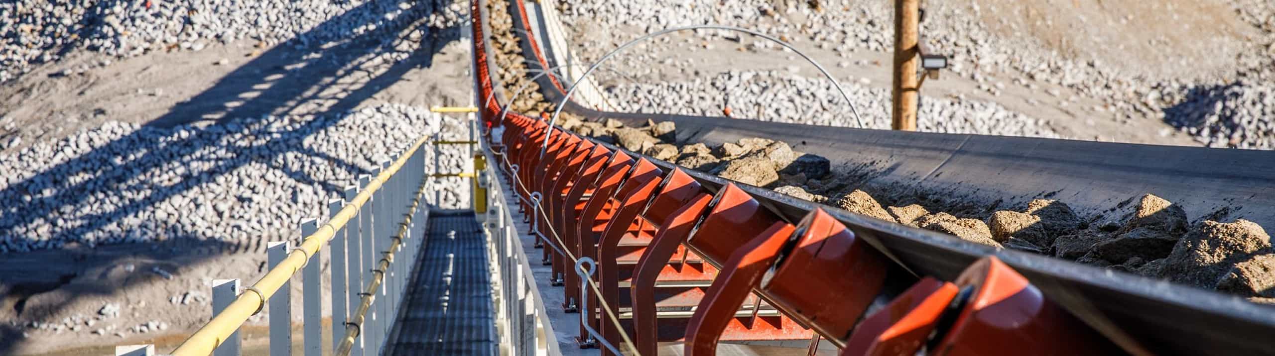 Surge tunnel reclaim conveyor in operation underneath the large surge (rock) pile at South Carolina site.