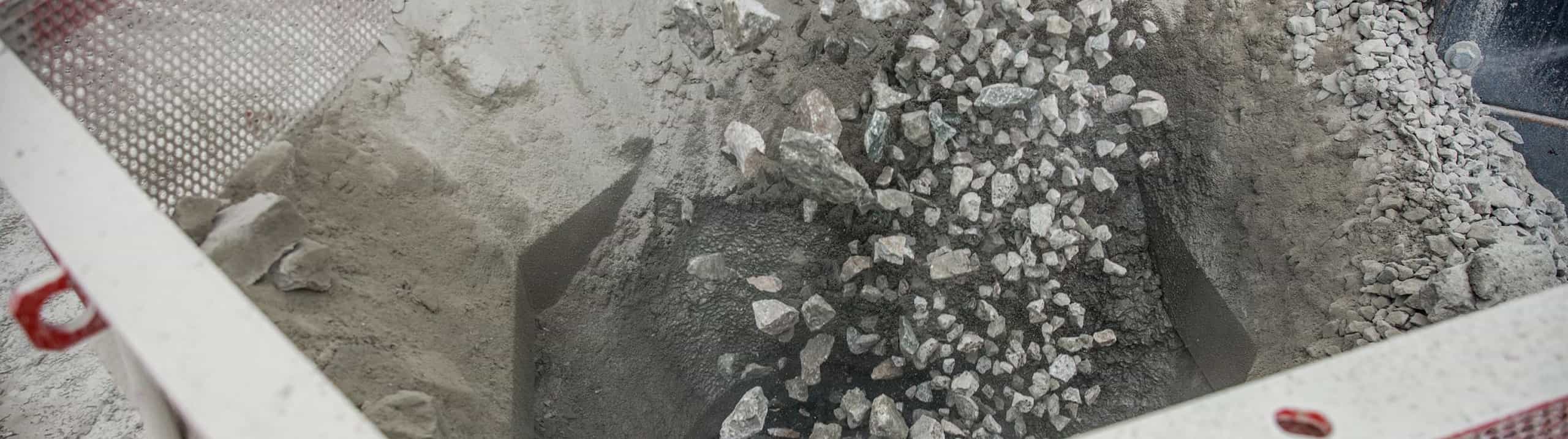 Closeup of rocks and stones feeding into a cone crusher.