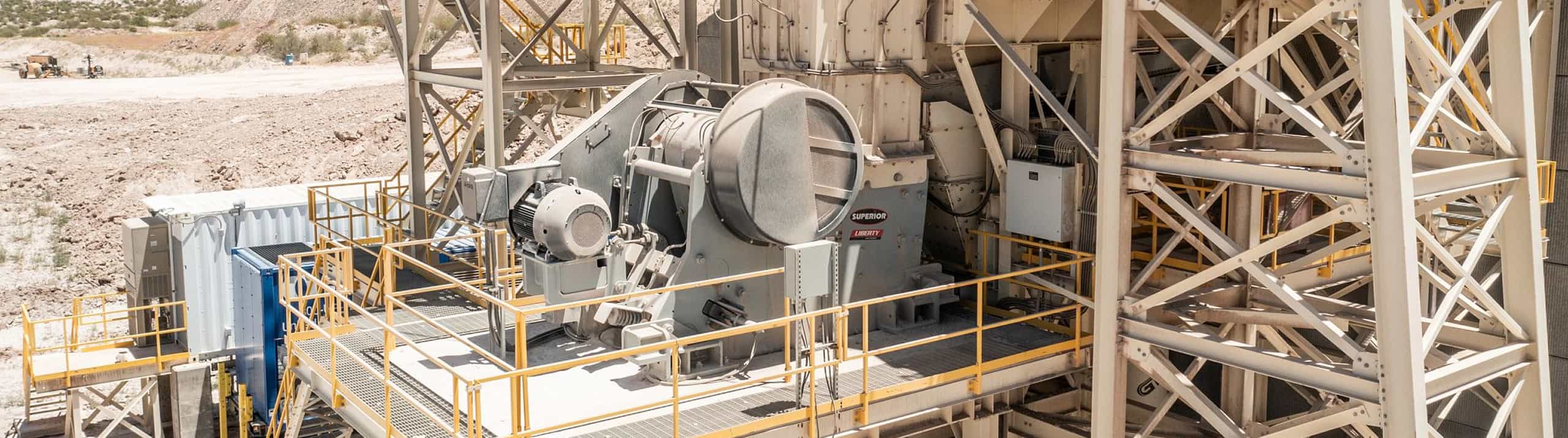 Liberty Jaw Crusher in primary crushing setup, processing shot rock on a raised platform at a stationary quarry site.